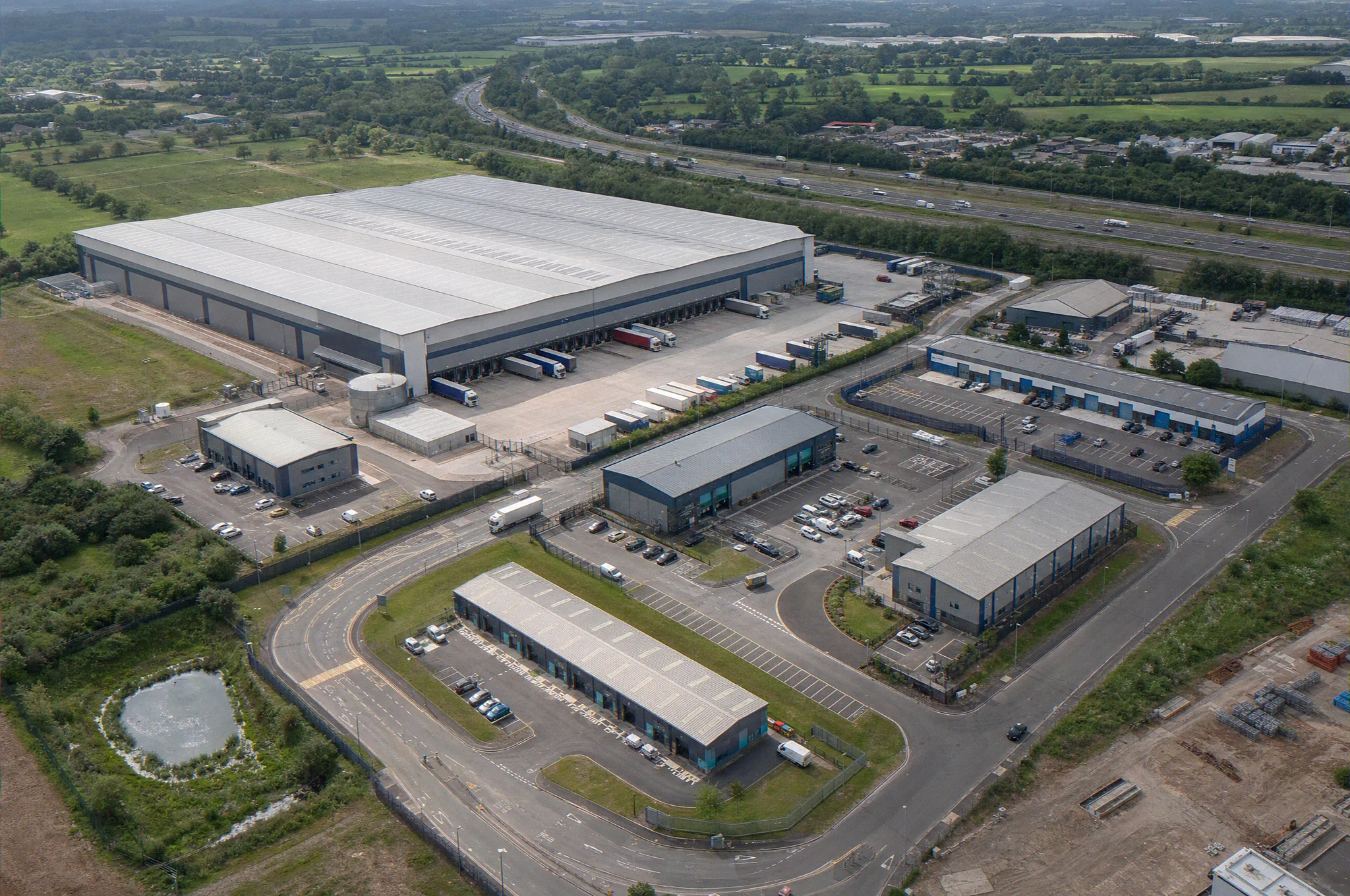 Industrial CGI portfolio overview, an aerial of a mixed industrial and logistics park spanning big-box distribution, mid-size units, and light industrial terraces, by StratumCGI